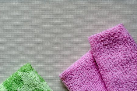 Soft multi-colored towels on a white textured background. Colorful bath towels. Health and hygiene...