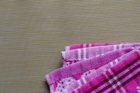 Pink towels on a brown background. Colorful kitchen towels. Abstract multitask background. View from above. Place for text.の写真素材