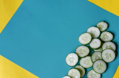 Sliced cucumber sliced across on a two-color background. Fresh fragrant cucumber cut into pieces. Health care, detox. Close-up. View from above. Selective focus.の写真素材