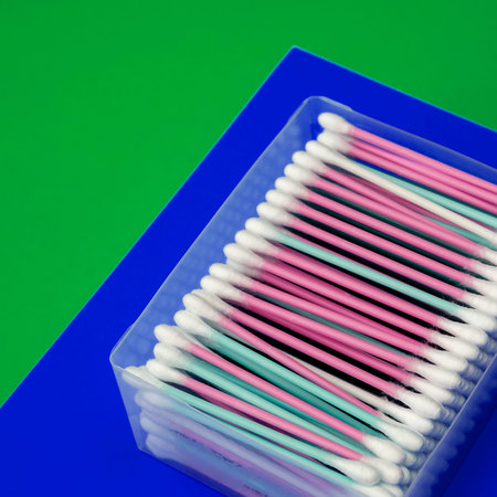 Blue-green background with multicolored cotton buds. A large set of cotton buds on a two-tone...