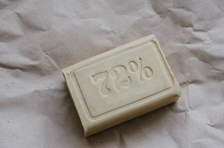 A piece of laundry soap 72% on brown paper. Single piece of eco soap close-up. Natural personal care products. Close-up.の写真素材