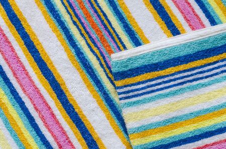 Multi-colored striped beach towel close-up. Colorful towel in rainbow colors. Positive colors. Abstract background. View from above.の写真素材