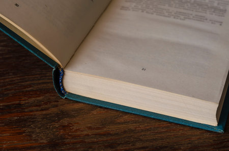 Open book on a wooden table. The hardcover book is open on page 31. Free space for text. Knowledge,...