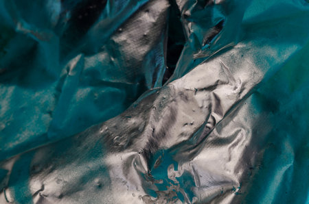 Silver paint on turquoise fabric. Synthetic fabric dyed with silver paint. Abstract multitask...