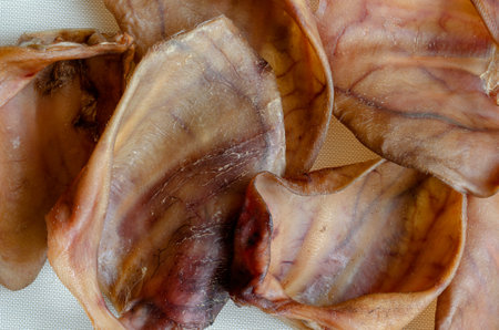 Natural chewing treats for pets background. A set of dried pork ears. Pet shop, pet supplies. View from above.の写真素材