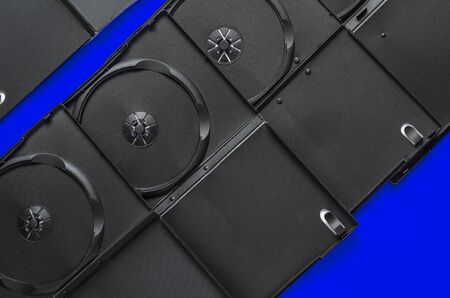 Black empty open boxes for DVD discs on a blue background. Abstract geometric background. Copy space. View from above.の写真素材