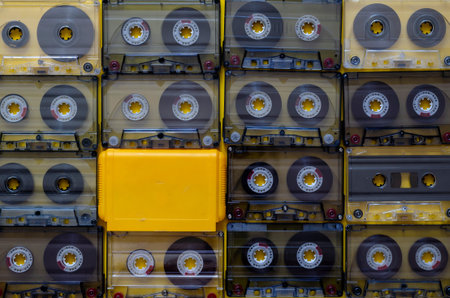 Creative background from audio cassettes and a yellow game cartridge. A set of random audio...