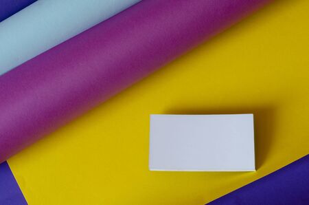 Blank business card on a multi-colored volumetric background. White blank business cards with shadow. Blue, turquoise, purple, yellow. Advertising, branding. View from above.の写真素材