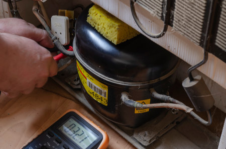 Nikolaev, Ukraine - June 30, 2020: an electrician with a multimeter checks the electrical resistance...