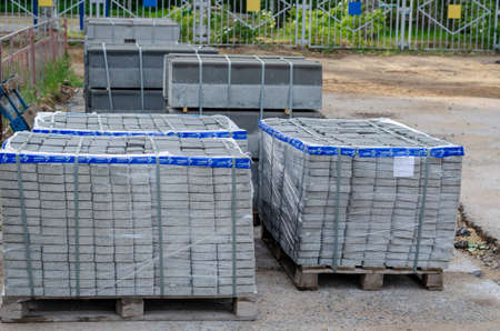 Nikolaev, Ukraine - May 18, 2020: new gray paving slabs on wooden pallets. Road repair work on improvement. Selective focus.のeditorial素材