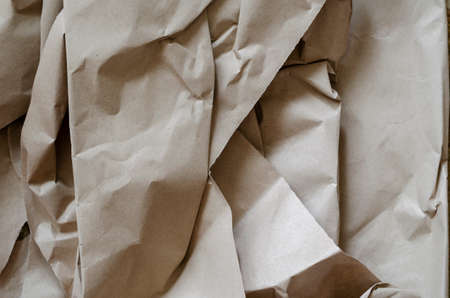 Crumpled brown paper texture. Wrapping paper for packaging. Eco-friendly materials. Top view at an angle. Selective focus.の写真素材
