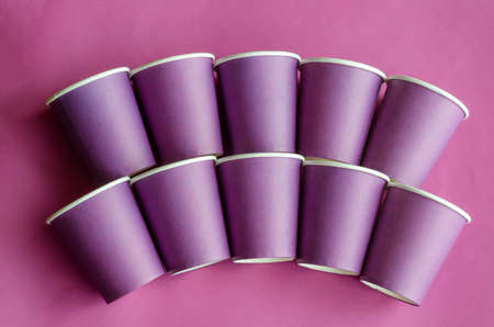 Geometric figure from lilac paper cups for coffee. Disposable glasses on a purple background. Eco-friendly dishes. Copy space. Selective focus.の写真素材
