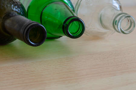 Close-up of three glass bottles with dust and dirt. Three empty beer bottles lie on the table. Alcohol addiction concept. Booze. Social issue. Copy space.の写真素材