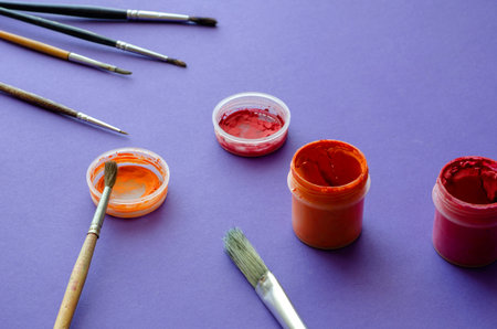 Drawing brushes and jars with gouache paint on a blue background. Various random brushes....
