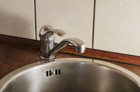 Round stainless steel kitchen sink with mixer. Top view at an angle of metal sink. Sanitary cleaning of the premises. Without anyone.の写真素材