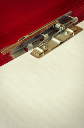 Red paper folder with clip close-up. Open folder with a metal clip. Office work, stationery. Copy...