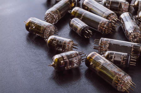 Random vacuum tubes on a black background. A group of radio tubes of different sizes and purposes. Shooting at eye level. Selective focus.の写真素材