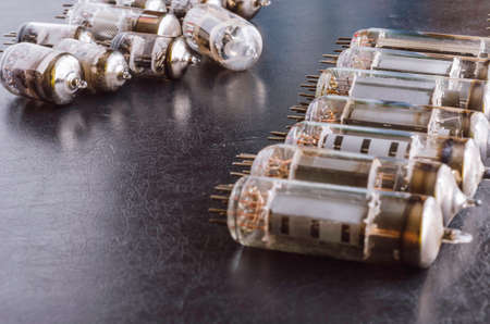 Random vacuum tubes on a black background. A group of radio tubes of different sizes and purposes. Shooting at eye level. Selective focus.の写真素材