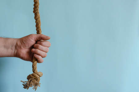 Hemp rope in a man's hand. The hand holds a thick natural cable. Adult male of European race. Interaction concept.の写真素材
