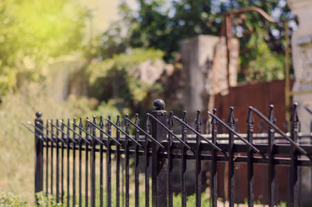 Black metal fence with decorative elements. Private Property Street Fencing. Summer sunny day. Selective focus.の写真素材