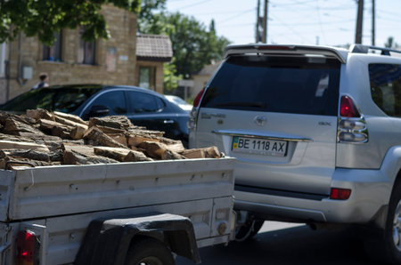 Nikolaev, Ukraine, August 17, 2020: Toyota Prado tows a trailer with firewood along a city street....