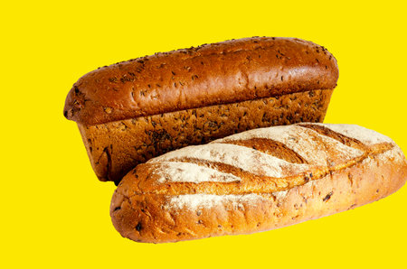 Two random loaves of rye bread on a yellow background. Demonstration of various varieties of...
