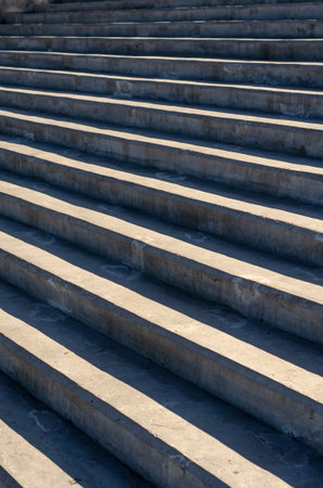Abstract geometric composition of concrete. Gray stair steps in sunlight with shadows. Wide stone...