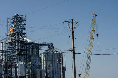 Construction process of a modern grain terminal in the seaport. Cylindrical metal silos for receiving and storing grain bulk cargo. Export of grain.の写真素材