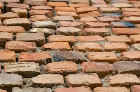 Red brick wall in receding perspective. Geometric composition of rectangular clay bricks. Multitasking background. Without anyone.の写真素材