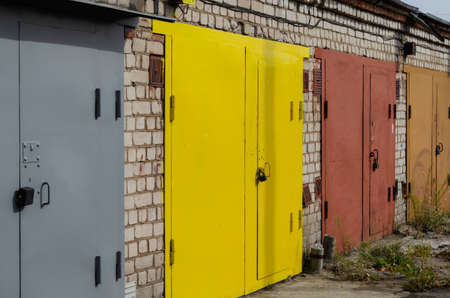 Self storage and mini storage garage. A row of multi-colored metal gates. Without anyoneの写真素材