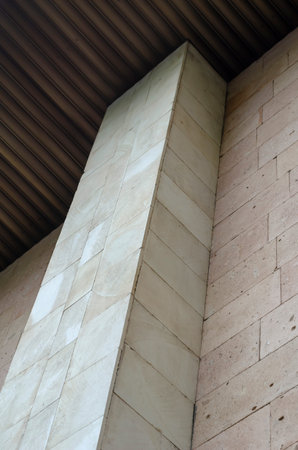 Abstract architectural composition. High building facade faced with rectangular stone slabs....
