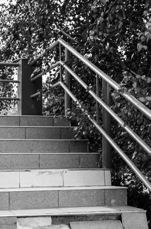 Stairs with railing outside. Black and white photo of a stone staircase with metal railing. Without anybody.の写真素材
