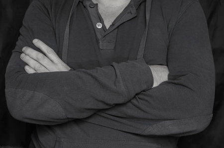 Body language concept. Black and white portrait of man with crossed arms on his chest. Man in closed...