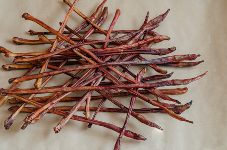 Group of dried beef chewing sticks randomly decomposed on brown surface. Treats for dogs. Dried Beef...