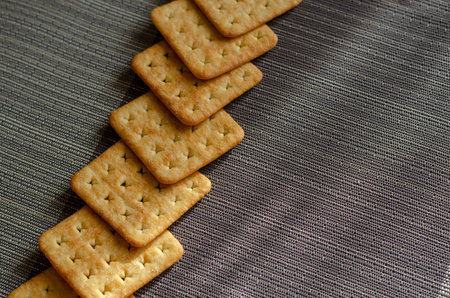 Groceries, snacks, food. Salted crispy crackers on a gray textured surface.の写真素材