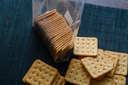 An open package of saltine crackers. Top view of the crispy treats in the clear packaging. Selective focus.の写真素材