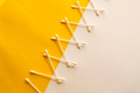 Creative multitasking background with cotton swabs on Yellow and White background. Concept, hygiene, body care, health care.の写真素材