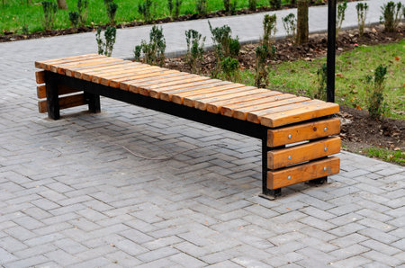 Creative empty wooden park bench. U-shaped bench made of metal and wooden bars. Modern urban lifestyleの写真素材