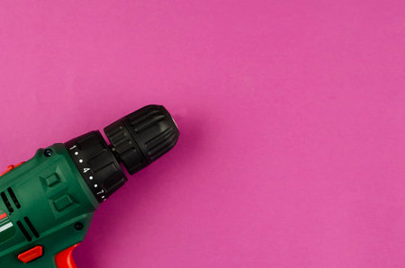 Handheld power tools, repair services, or home handyman. Electric drill on a purple background. Copy space. Flat lay.の写真素材