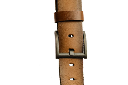 Old Brown leather belt isolated on white background. Worn Men`s belt. Leather belt with metallic...