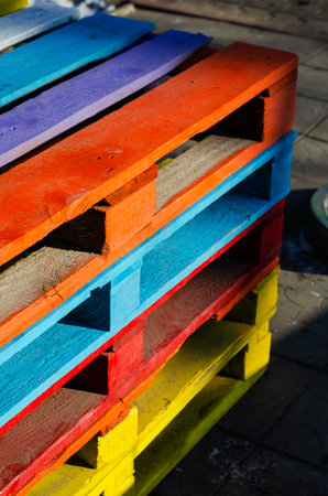 Stack of colorful wooden pallets outside. Containers are designed for the transportation, packing, storage, and warehousing of products. Selective Focus.の写真素材