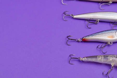 Artificial lures for fishing for predatory fish on a blue background. Random wobblers are lined up. Fishing, tackle. Selective Focus.の写真素材