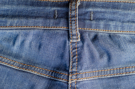 The back of the blue jeans with yellow threads. Detailed shot of the classic denim pants. Casual wear.の写真素材