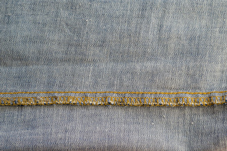 Wrong side of jeans fabric. Detailed shot of the classic yellow threaded fabric. Copy space