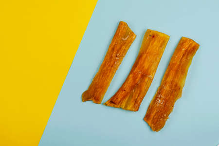 Natural dental treats for dogs. Chew Treats. Dried beef tendons on a two-color background. Flat Lay.の写真素材