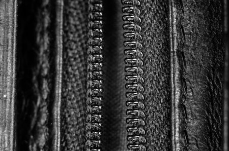 Macro shot of a black zipper. Detailed fabric, natural black leather and zipper. Monochrome.の写真素材