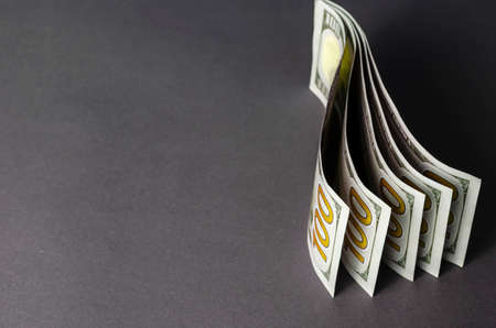Creative abstract background with one hundred dollar bills with copy space. Five banknotes mounted vertically on a gray background. Close-up, selective focus.の写真素材