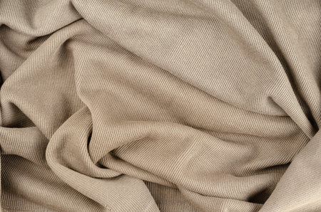 Crumpled brown fabric background. Light brown abstract multitasking background.