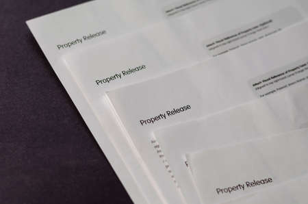 Blank property release forms on a gray table. Several copies of the document printed on white paper. Selective focus.の写真素材