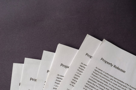 Blank property release forms on a gray table. Several copies of the document printed on white paper....